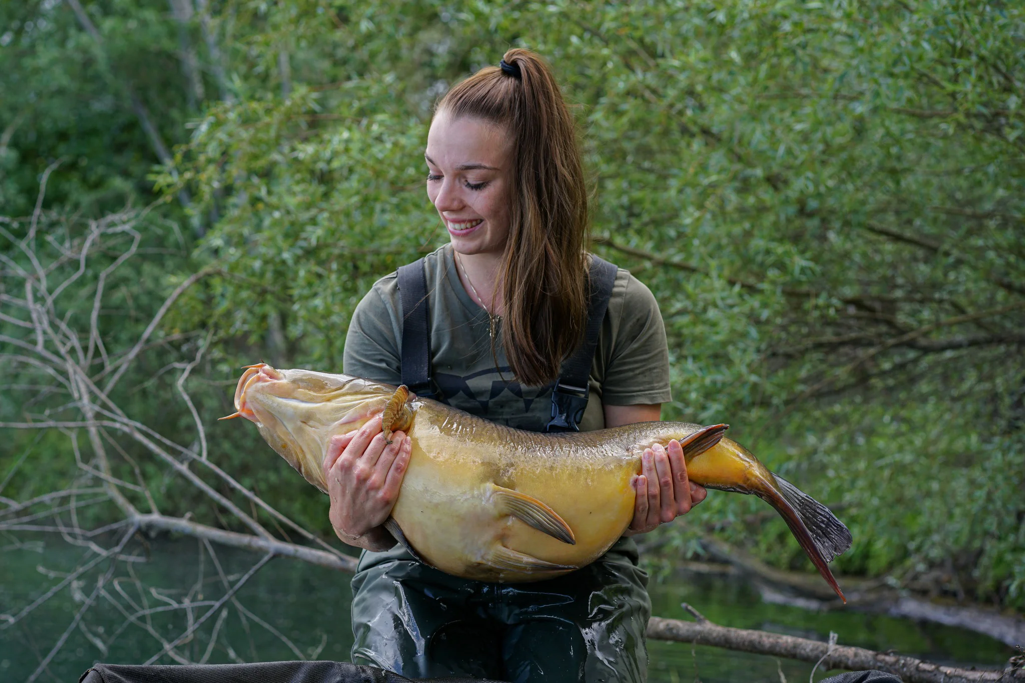Karpfenanglerin mit großem Karpfen